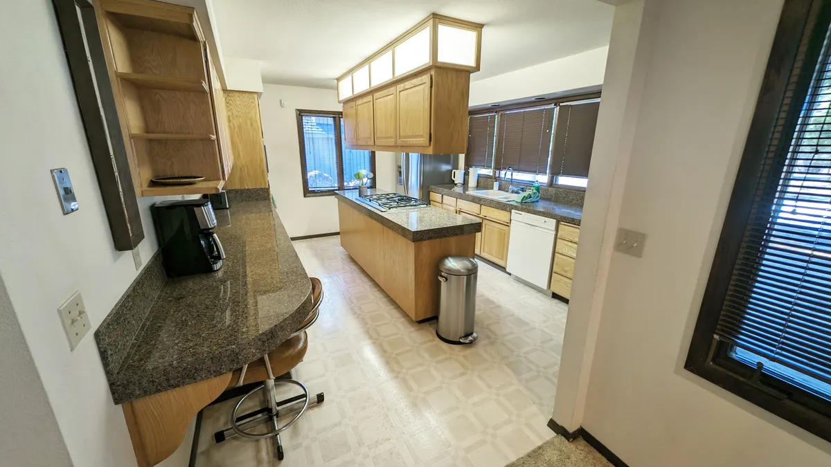 A spacious kitchen island sits at the center of an open cooking area, with bar seating that encourages socializing and togetherness. The kitchen features modern appliances and ample space, perfect for group meals and morning coffee before heading out to the resort amenities.