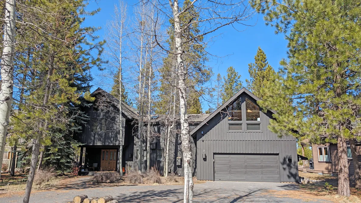 A welcoming view of the home's main entrance, featuring large windows, a spacious garage, and surrounding greenery. The image radiates warmth and hints at the adventure awaiting inside and nearby, setting the stage for memorable family getaways.